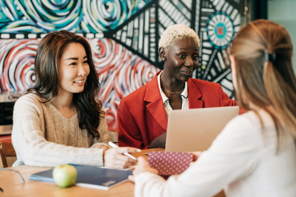 A diverse group of women collaborating in an artistic workspace, fostering teamwork and creativity.